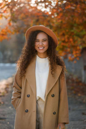 Portrait of beautiful African-American woman in casual outfit on city street
