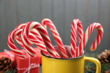 Many sweet candy canes in cup on gray background, closeup. Traditional Christmas treatの写真素材