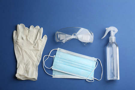 Flat lay composition with medical gloves, masks and hand sanitizer on blue backgroundの写真素材
