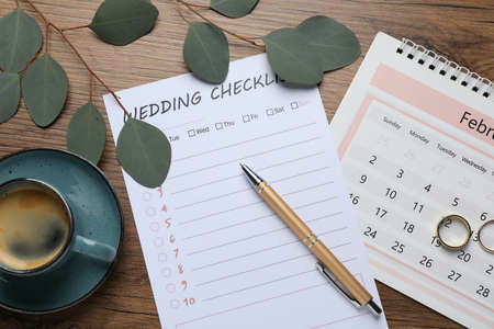 Flat lay composition with Wedding Checklist and calendar on wooden tableの写真素材