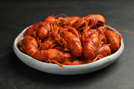 Delicious boiled crayfishes in plate on black tableの写真素材