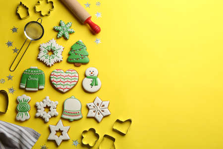Flat lay composition with delicious gingerbread cookies and kitchen items on yellow background....