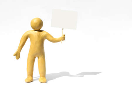 Human figure made of yellow plastic holding blank sign on white background. Space for text