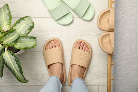 Woman wearing comfortable rubber slippers indoors, top view