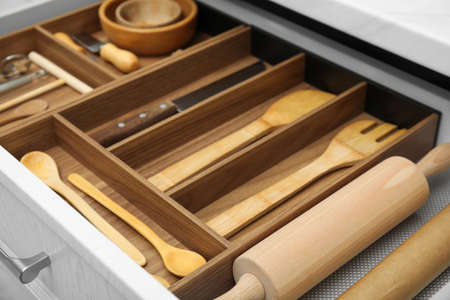 Open drawer of kitchen cabinet with different utensils, closeupの写真素材