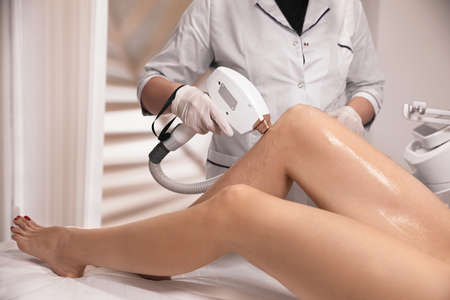 Woman undergoing laser epilation procedure in beauty salon, closeupの写真素材