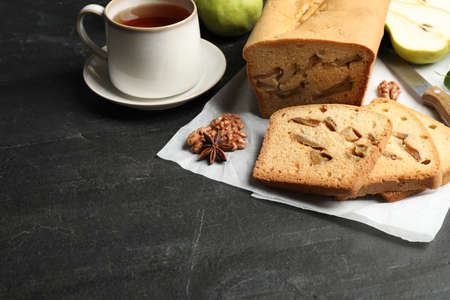 Composition with tasty pear bread on black slate table. homemade cake