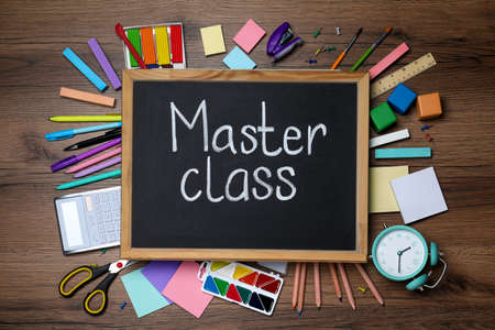 Blackboard with words Master Class surrounded by different stationery on wooden table, flat layの写真素材