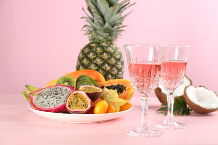 Delicious exotic fruits and wine on pink wooden tableの写真素材