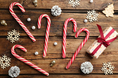 Flat lay composition with candy canes and Christmas decor on wooden backgroundの写真素材