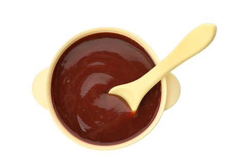 Bowl and spoon with tasty pureed baby food isolated on white, top viewの写真素材