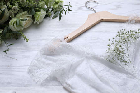 Beautiful wedding dress and flowers on white wooden background, closeupの写真素材