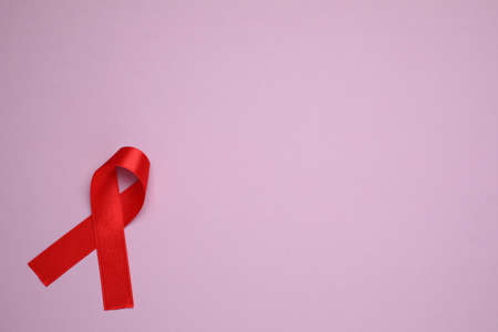 Top view of red ribbon on violet background, space for text. AIDS disease awarenessの写真素材