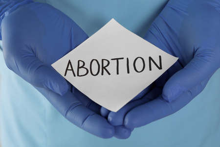 Doctor holding paper card with word ABORTION, closeupの写真素材