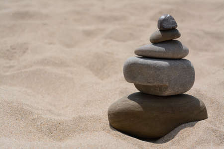 Stack of stones on beautiful sandy beach, space for textの写真素材