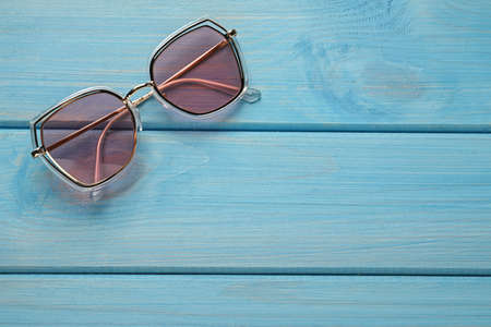 New stylish sunglasses on turquoise wooden table, top view. Space for textの写真素材