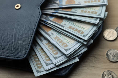 Dollar banknotes, coins and wallet on wooden table, closeup. money exchangeの写真素材