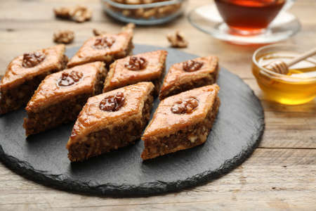Delicious honey baklava with walnuts served on wooden table, closeupの写真素材