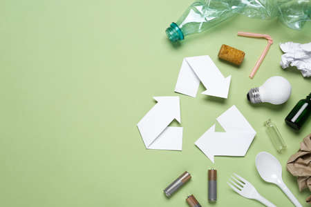 Recycling symbol and garbage on light green background, flat lay. Space for textの写真素材