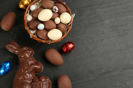 Flat lay composition with chocolate Easter bunny and eggs on black table. Space for textの写真素材
