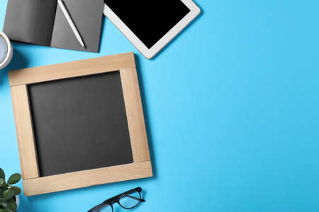 Flat lay composition with small chalkboard on light blue background, space for textの写真素材