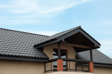 Beautiful house with gray roof against blue sky