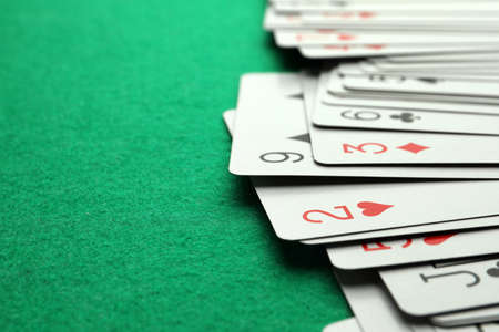 Deck of playing cards on green table, closeup. Space for textの写真素材