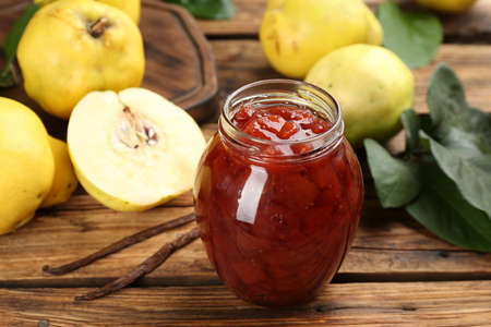 Delicious quince jam and fruits with vanilla on wooden table, closeupの写真素材