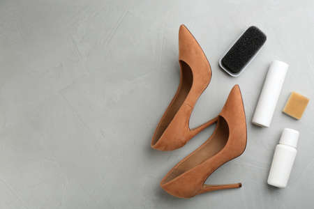 Stylish footwear with shoe care accessories on light gray stone table, flat lay. Space for textの写真素材