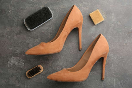 Stylish footwear with shoe care accessories on gray stone table, flat layの写真素材