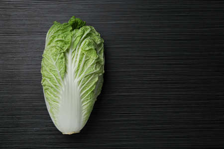 Fresh ripe Chinese cabbage on black wooden table, top view. Space for textの写真素材