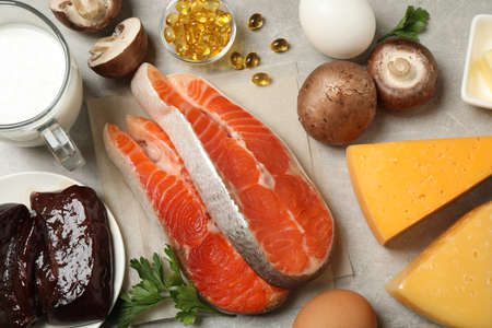 Flat lay composition with products rich in vitamin D on light gray table