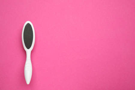 White foot file on pink background, top view with space for text. pedicure tool