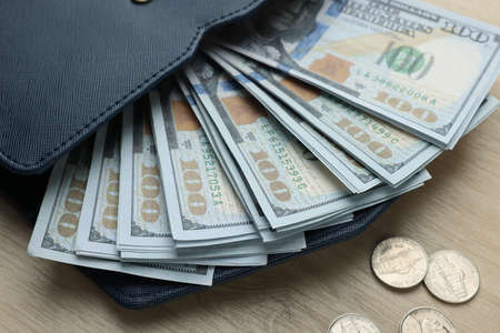 Dollar banknotes, coins and wallet on wooden table, closeup. money exchange