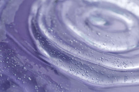 Transparent shower gel on violet background, closeupの写真素材
