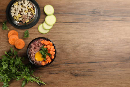 Pet food and natural ingredients on wooden table, flat lay. Space for textの写真素材