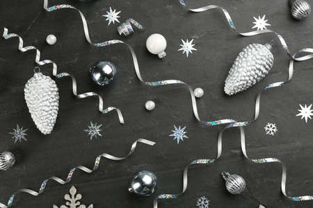 Flat lay composition with serpentine streamers and Christmas decor on black background