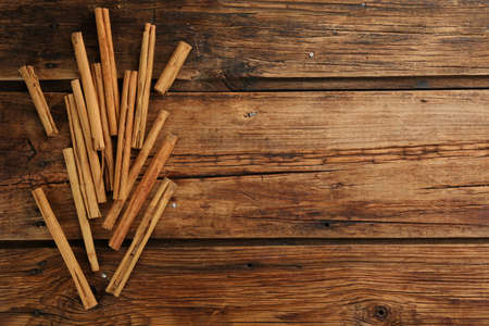 Aromatic cinnamon sticks on wooden table, flat lay. Space for textの写真素材