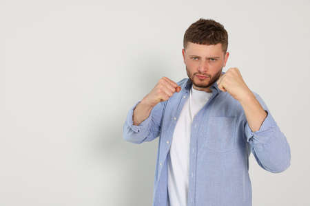 Young man ready to fight on white background, space for textの写真素材