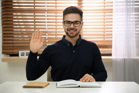 Happy man using video chat in modern office, view from web camera