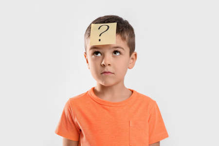 Emotional little boy with question mark on white backgroundの写真素材
