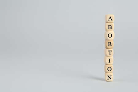 Word Abortion made of wooden cubes on light gray background. Space for textの写真素材