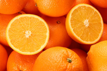 Cut and whole fresh ripe oranges as background, top viewの写真素材