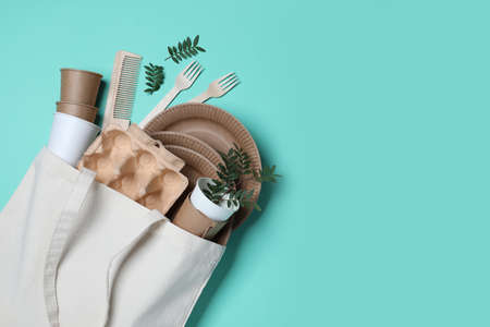 Eco bag with different disposable items on turquoise background, flat lay and space for text. Recycling conceptの写真素材