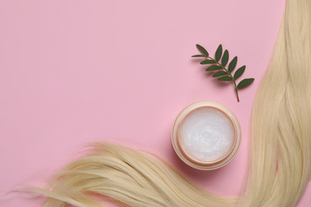 Lock of healthy blond hair, green twig and cosmetic product on pink background, flat lay. Space for textの写真素材