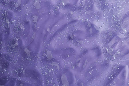 Texture of transparent shower gel on violet background, closeupの写真素材