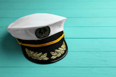 Peaked cap with accessories on turquoise wooden background, space for textの写真素材