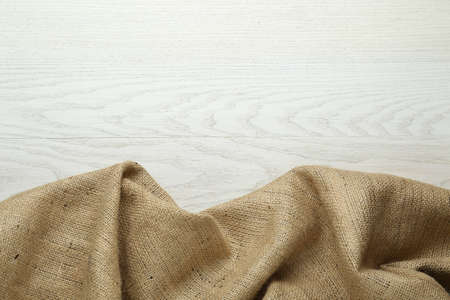Natural burlap fabric on white wooden table, top view. Space for textの写真素材
