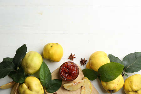 Delicious quince jam and fruits on white wooden table, flat lay. Space for textの写真素材
