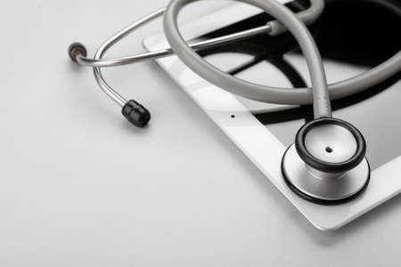 Medical stethoscope and tablet on white background, closeup. Space for textの写真素材